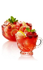 The Blushing Tease is a summer punch made from gin, lemon juice, simple syrup, lemon sherbet, green tea, raspberries, orange bitters and maraschino liqueur, and served from a small pitcher. Recipe serves 2.