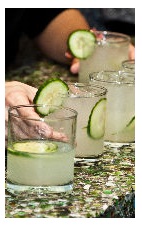 The Khira drink recipe is made from Okanagan gin, lime juice, cardamom syrup, ginger beer and cucumber, and served over ice in a rocks glass garnished with a cucumber slice.