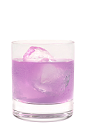 The Coco Berry Bliss is a purple drink made from Hpnotiq Harmonie, coconut vodka and club soda, and served over ice in a rocks glass.