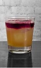The Sao Paulo Sour is an orange and purple colored drink recipe made from Cedilla acai liqueur, bourbon, egg white, lemon juice and simple syrup, and served over ice in a rocks glass.