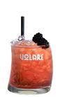 The Volare Bramble is a red colored cocktail made from Vlare blackberry liqueur, gin, lemon juice, simple syrup and blackberries, and served over ice in a rocks glass.